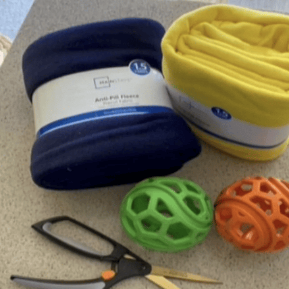fleece fabric, rubber balls, and scissors to make a fleece tug toy for dogs